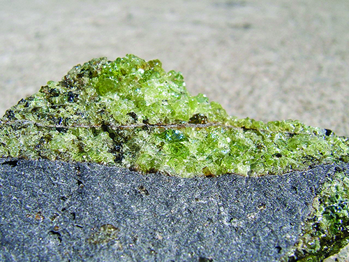 Olivine with minor pyroxene (brown) on vesicular basalt